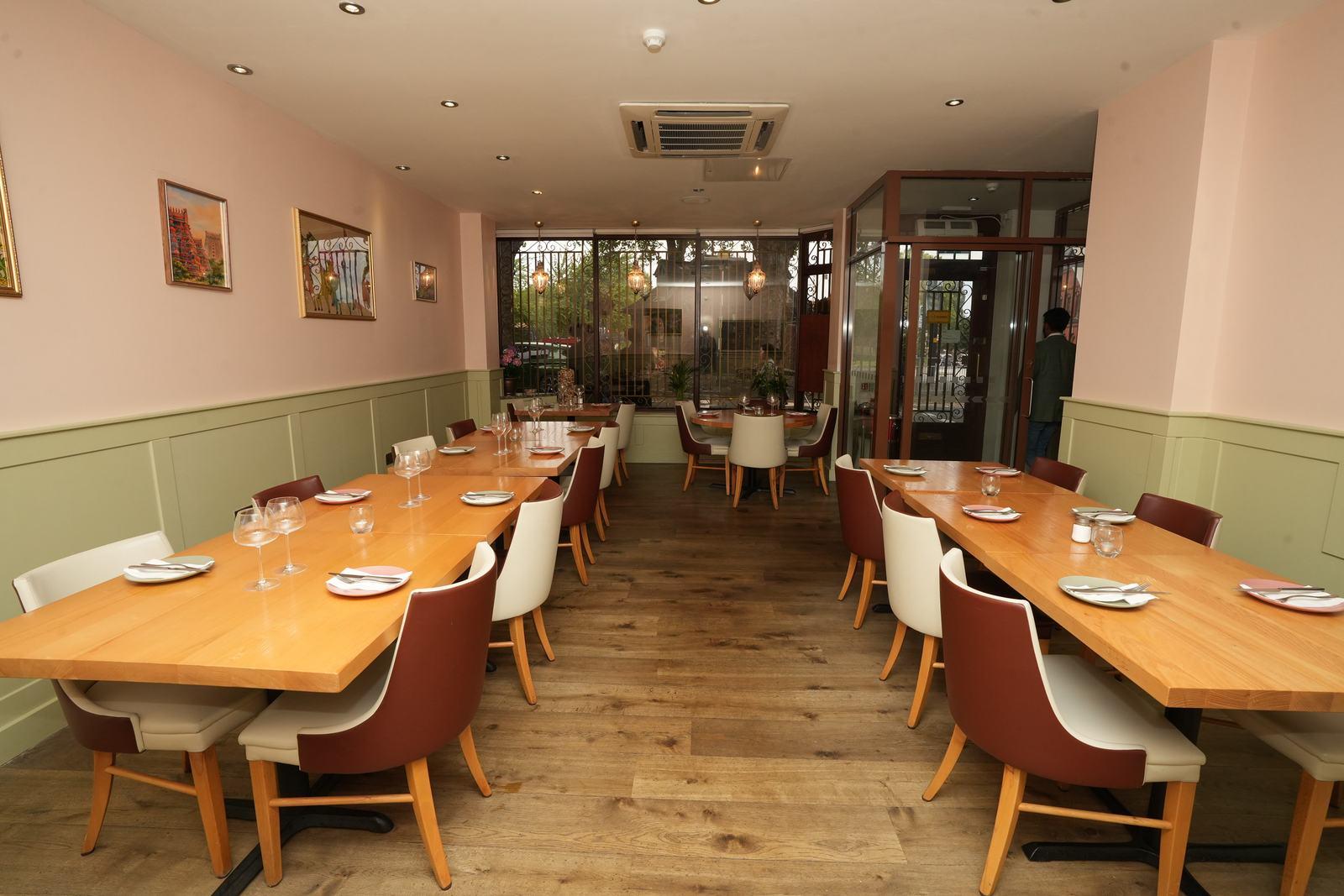 Wide view down the dining room between long tables at Aara