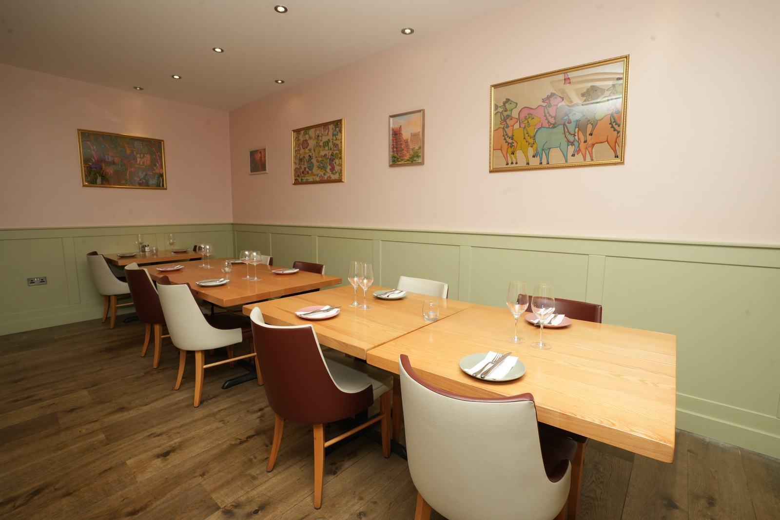 Aara's dining room — light wood tables, warm lighting and framed art