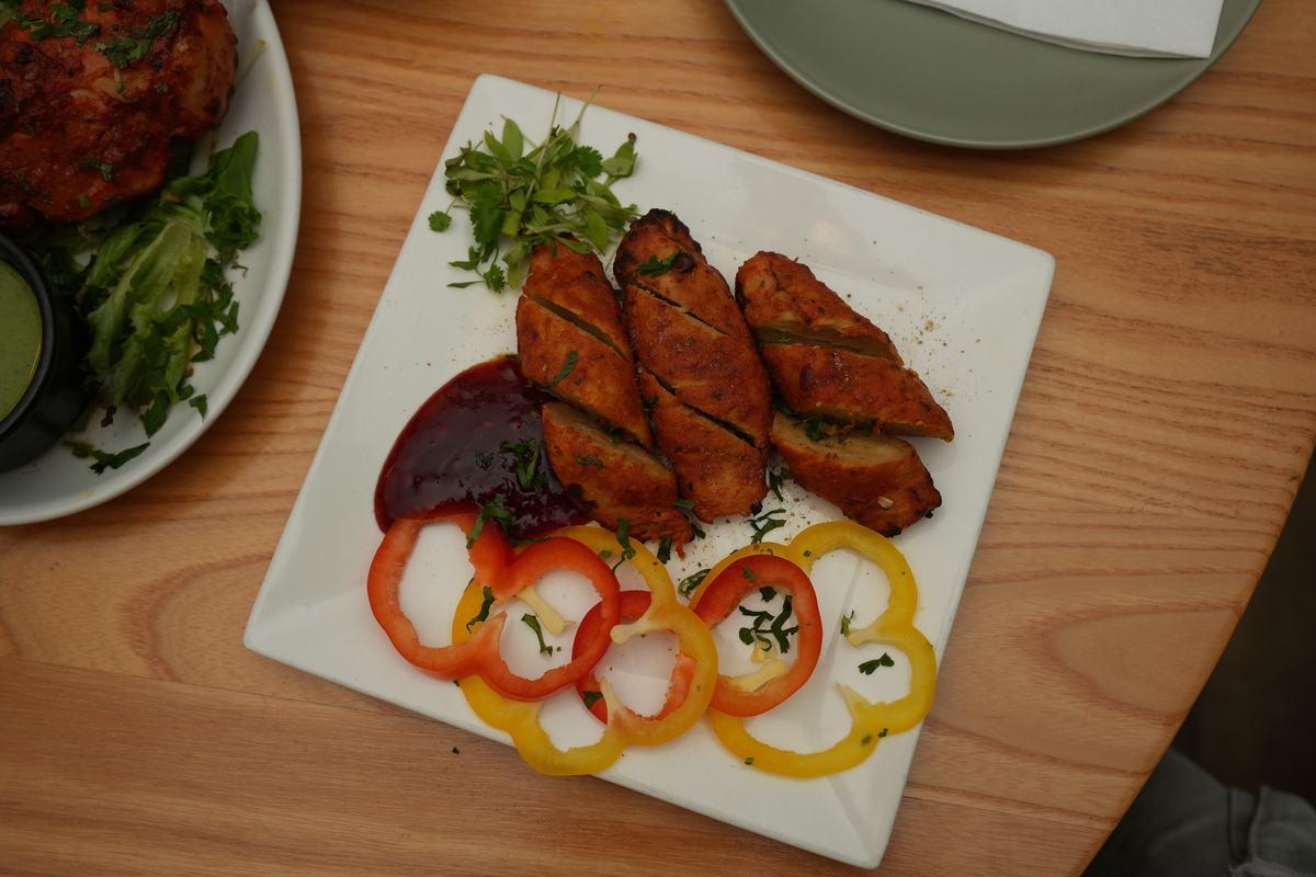 Chicken tikka pieces with char and marinade glaze on a plate