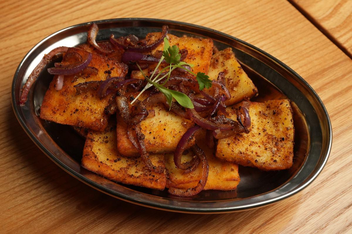 Paneer tikka — chargrilled spiced paneer with onions on a steel platter