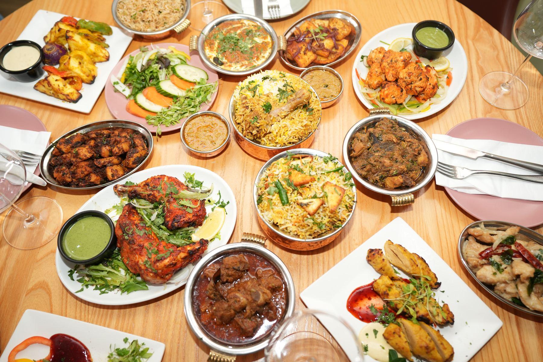 Plated curries, biryani and tandoori dishes served together at Aara